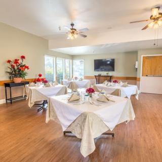A beautifully arranged dining area featuring elegant tables and floral decorations.