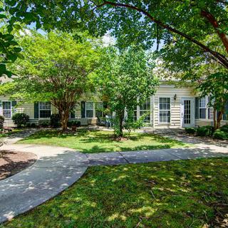 A charming residential home with a lush garden and walkway.