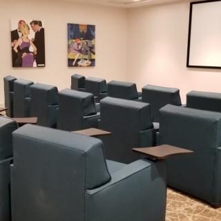 A cozy home theater setup with comfortable seating and movie posters on the walls.