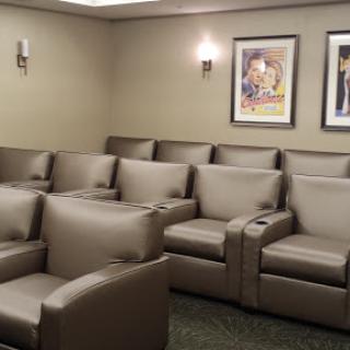 A cozy waiting room featuring comfortable leather seating and decorative artwork on the walls.
