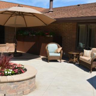 A cozy patio with comfortable seating and an umbrella, perfect for relaxing outdoors.