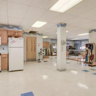 Spacious kitchen area with appliances and ample lighting.