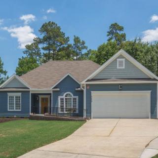 A suburban house with a blue exterior, garage, and a well-maintained yard.