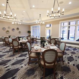 An elegant dining area with chandeliers and neatly set tables.