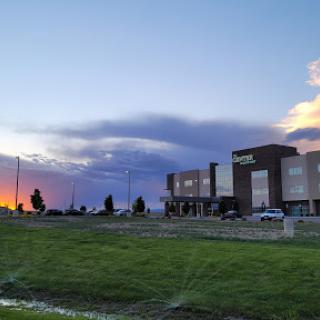 A serene sunset reflecting off the clouds beside a modern building.