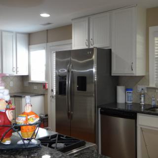 A modern kitchen with stainless steel appliances and white cabinets.