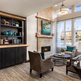 A modern and cozy living room with a fireplace, stylish furniture, and a well-decorated bookshelf.