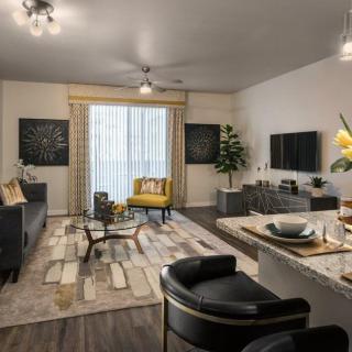 A modern living room with stylish furniture and decor, featuring a cozy seating and dining area.