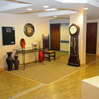 A spacious lobby featuring elegant furnishings, decorative vases, and a classic clock.