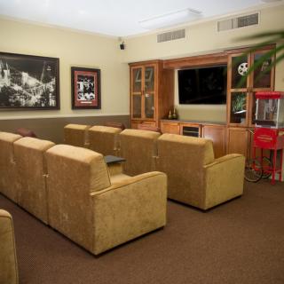 A cozy home theater setup with comfortable seating, a large screen, and a popcorn machine.