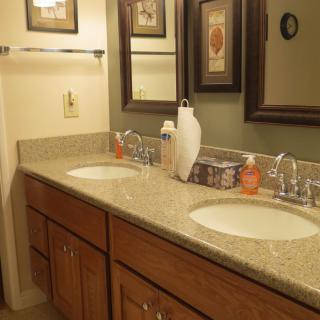 A neatly organized bathroom with a double sink and mirrors above.