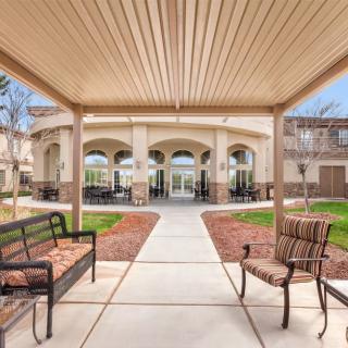 A serene outdoor seating area with benches and a pathway leading to a building's entrance.