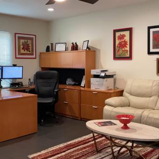 A well-organized home office with a desk, computer, and comfortable seating.
