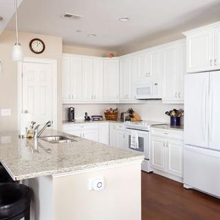 A modern kitchen with white cabinets and an island.
