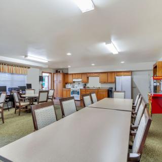 A spacious meeting area with a kitchenette and seating arrangement.