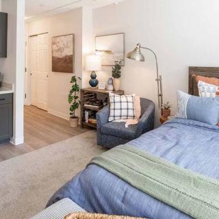 A cozy bedroom with modern decor, featuring a comfortable bed, stylish chair, and various decorative elements.