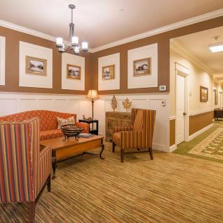 A warm and inviting lobby area featuring comfortable seating, modern lighting, and framed artwork on the walls.