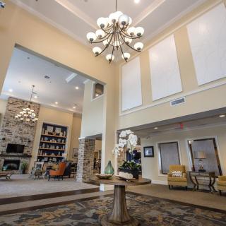 A spacious lobby with elegant chandeliers and modern decor.
