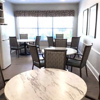 A well-lit dining area with multiple tables and chairs.