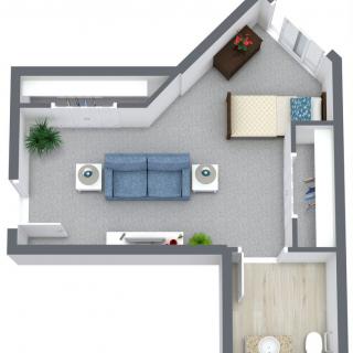 A top-down view of a small apartment floor plan, featuring a living room with a sofa and coffee tables, and a separate bedroom area.
