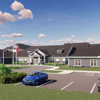 A modern building with a parking lot and flags under a blue sky.