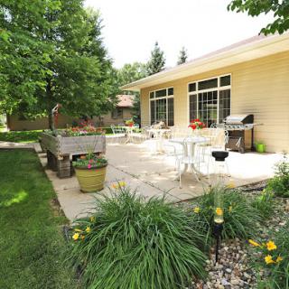 A serene outdoor patio space surrounded by lush greenery, perfect for relaxation and gatherings.
