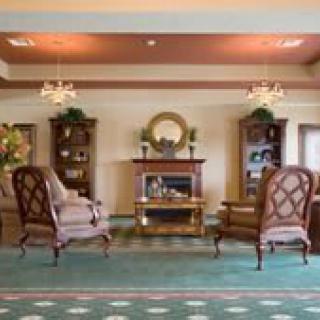 A classic living room interior with elegant furniture, a fireplace, and chandeliers.