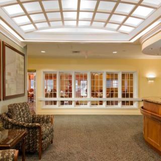 A welcoming lobby area featuring a reception desk, comfortable armchairs, and an elegant ceiling design.