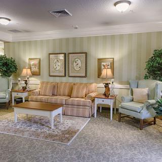 A cozy living room with a sofa, armchairs, coffee table, and decorative lamps.