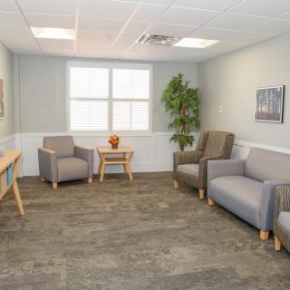A clean and modern waiting room with comfortable seating and a large window.