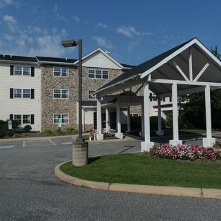 A residential building with a covered entrance and landscaped surroundings.