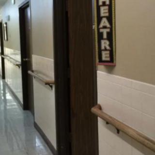 A hallway with a theatre sign and multiple doors.