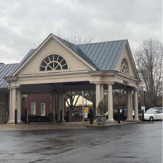 A welcoming entrance of a commercial building under a cloudy sky.