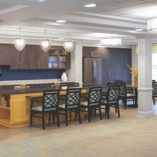 A modern kitchen interior with a seating area and elegant pendant lighting.