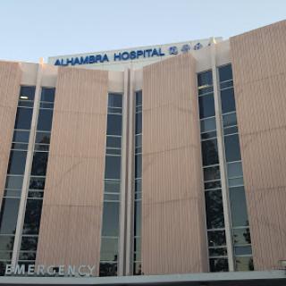 Exterior view of Alhambra Hospital, showcasing its modern design and large windows.