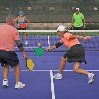 Players engaged in a game of pickleball on an outdoor court.