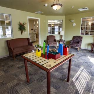 A waiting room featuring a table with decorative bottles and comfortable seating.