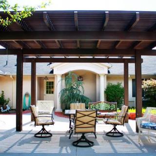 A beautifully designed patio with a wooden pergola and outdoor furniture set.