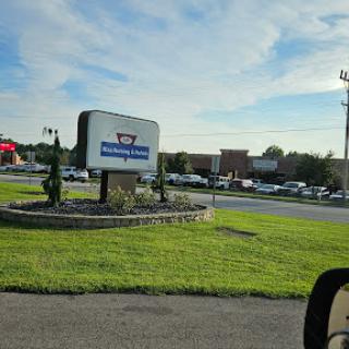 A view of a hotel sign along with surrounding landscape and vehicles.