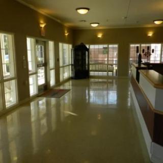 A well-lit hallway with large windows and shiny floors.