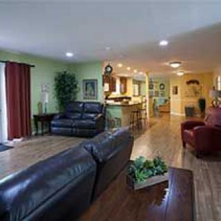 Spacious open-concept living area with leather seating and a view into the kitchen.
