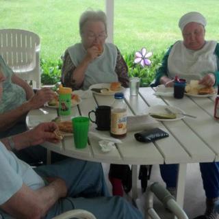 A group of people enjoying a meal together at an outdoor table.