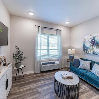 A modern living room with a blue sofa, abstract artwork, and a stylish coffee table.