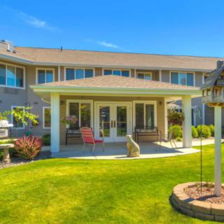 A beautiful suburban house with a well-maintained backyard and patio.