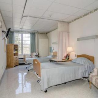 A clean and well-organized hospital room with two patient beds.