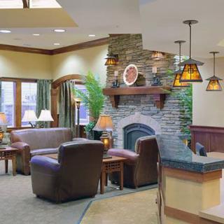 A cozy living room with a stone fireplace, leather seating, and warm lighting.