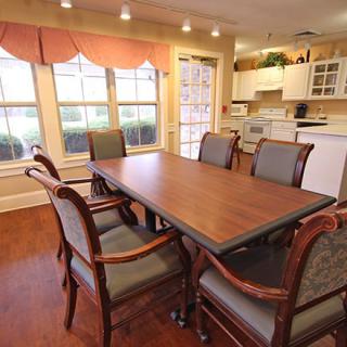 A cozy dining area with a wooden table and chairs, adjacent to a kitchen.