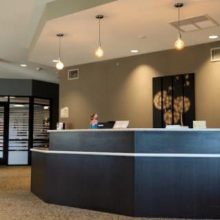 A modern office reception area with a sleek curved desk and contemporary decor.