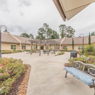 A serene courtyard with a pathway, benches, and landscaped gardens surrounded by buildings.