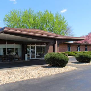 A modern commercial building with a landscaped front, featuring large windows and an inviting entrance.